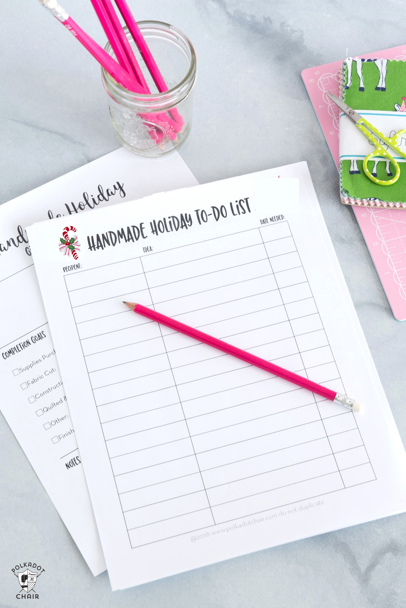 christmas planner pages on white marble table with pencils