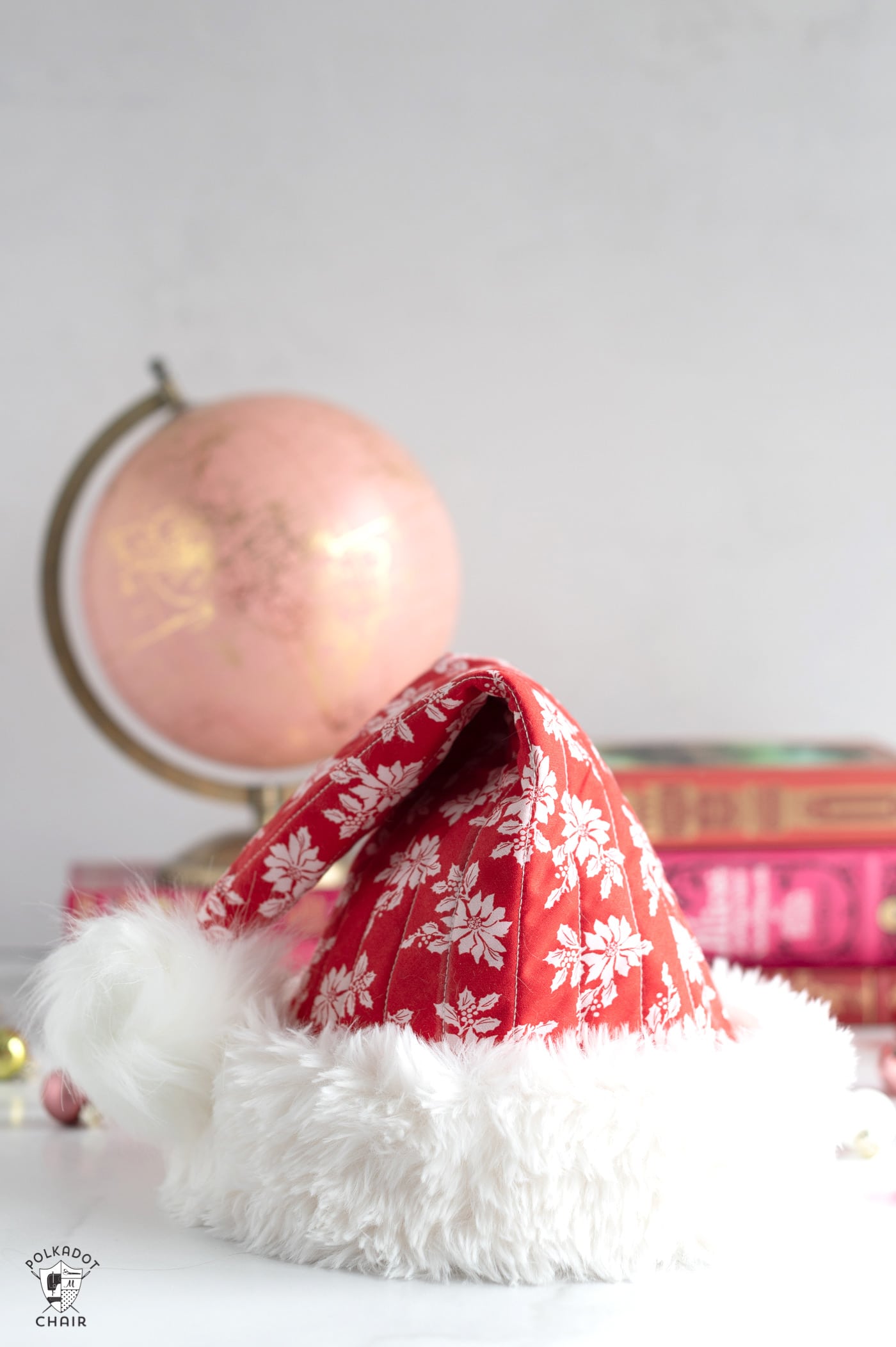 quilted santa claus hats on white table with christmas decor