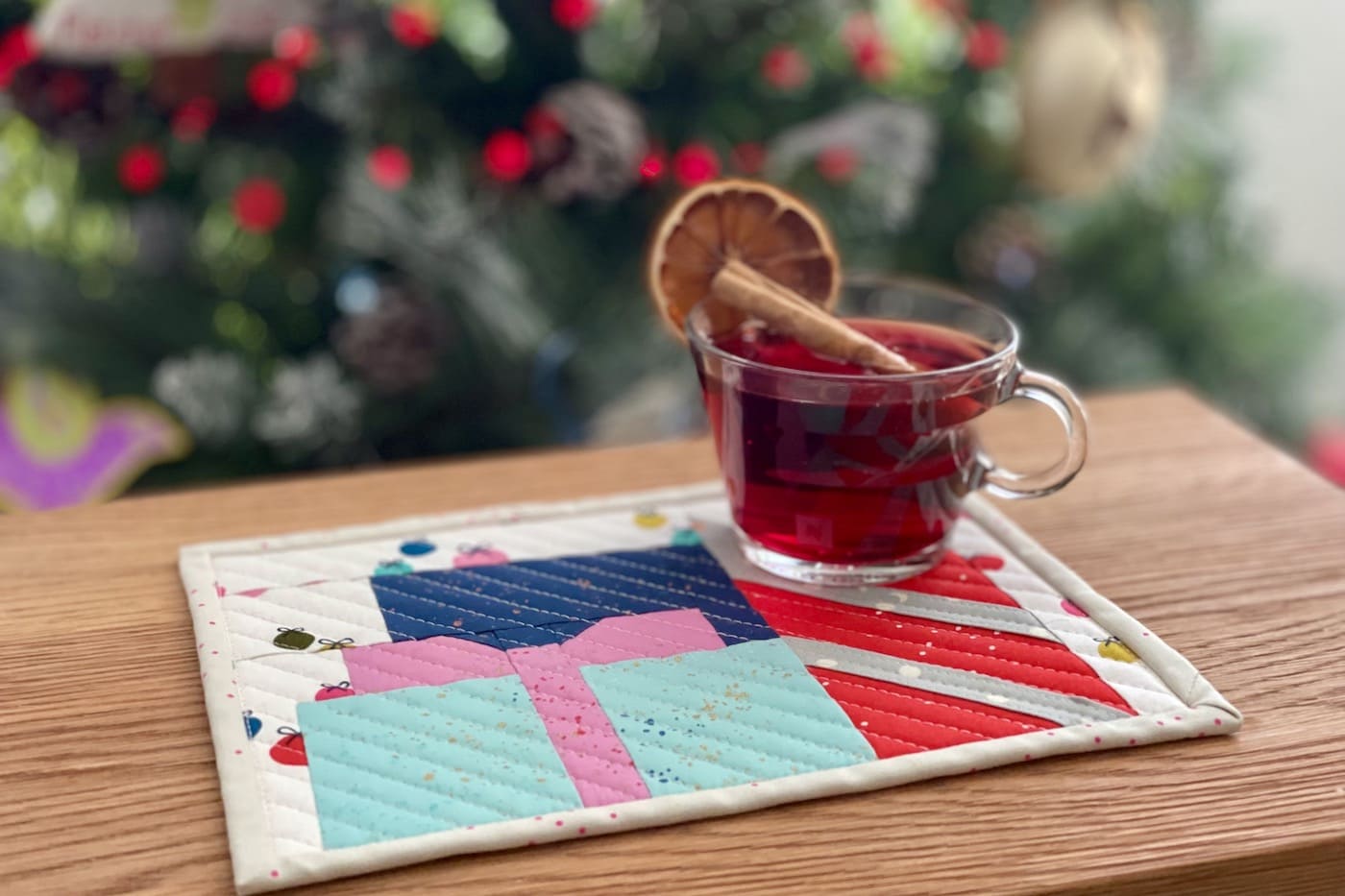 colorful presents mug rug on wood table in front of Christmas tree