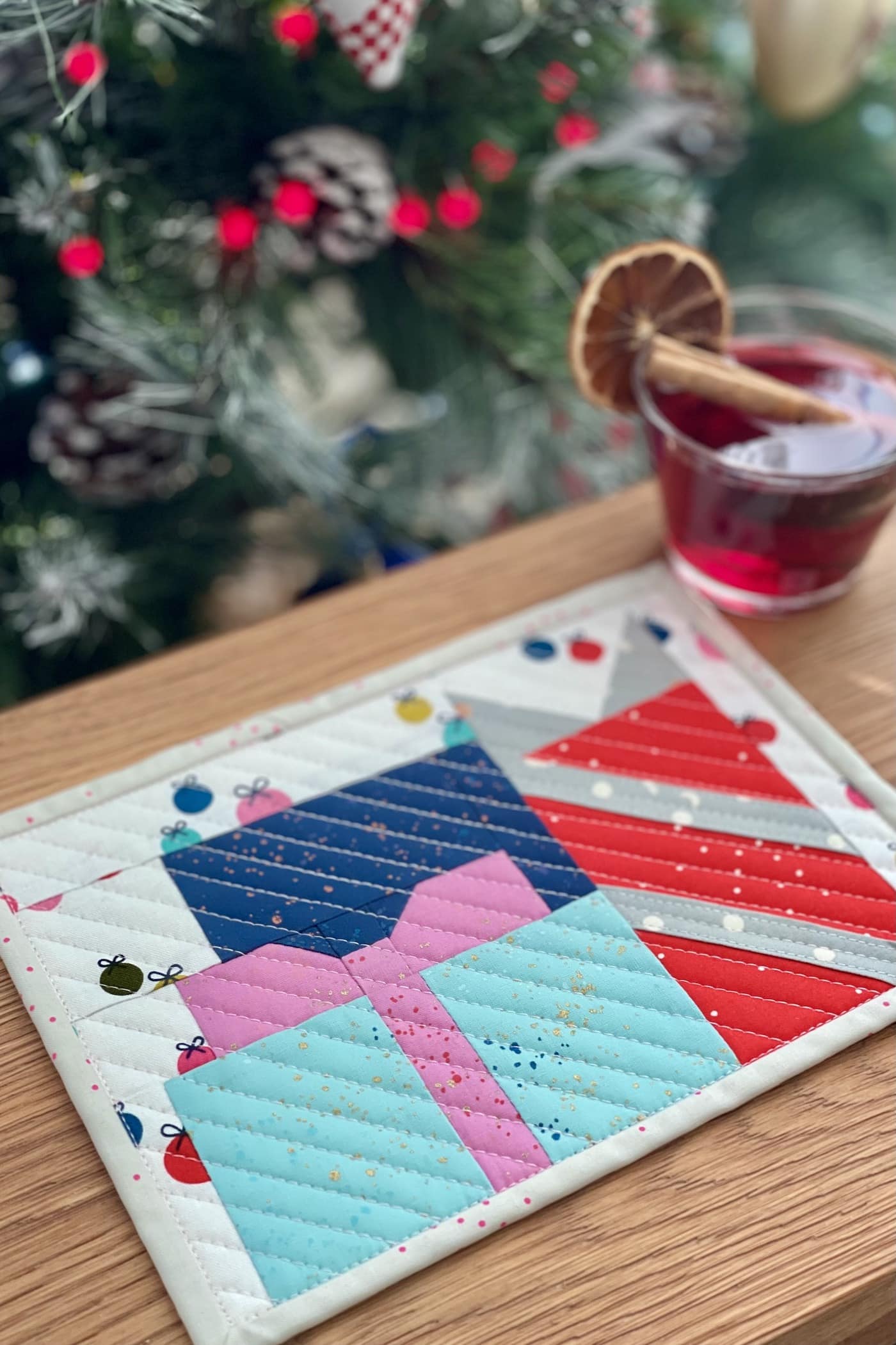 colorful presents mug rug on wood table in front of Christmas tree