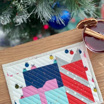 colorful presents mug rug on wood table in front of Christmas tree
