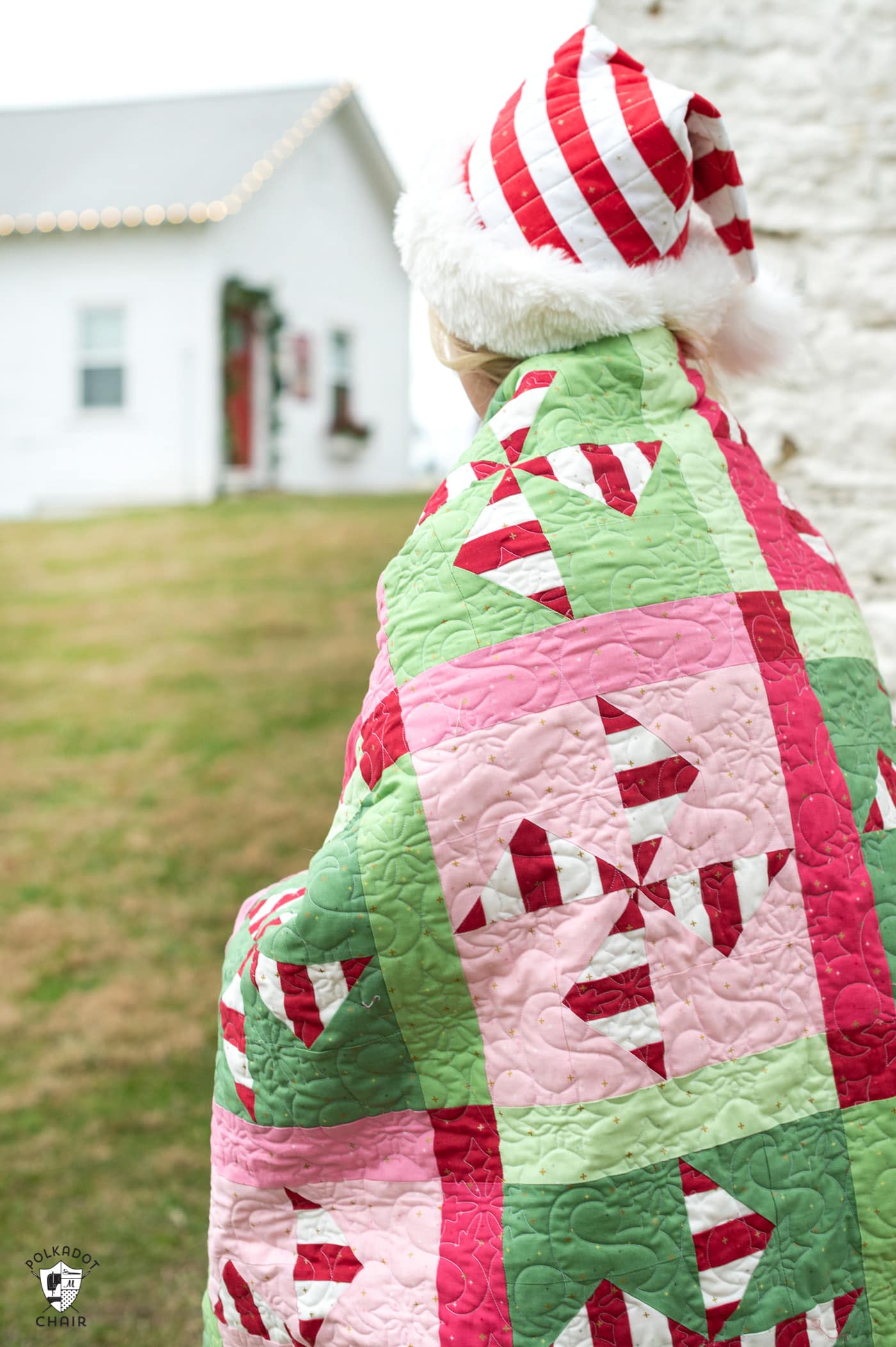 woman outdoors with red and green christmas quilt wrapped around her shoulders