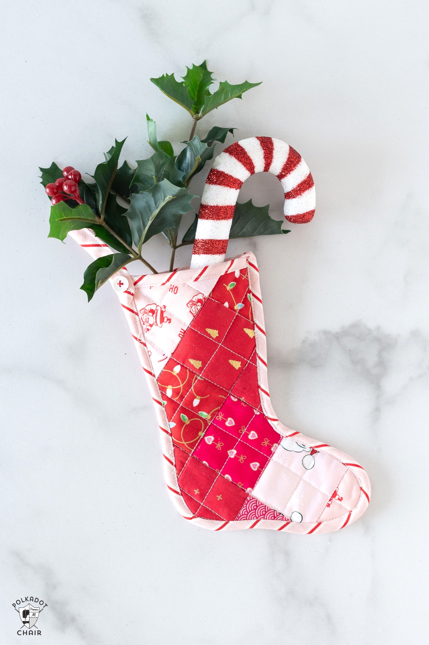 Pink and red mini quilted stockings on white tabletop with Christmas decorations