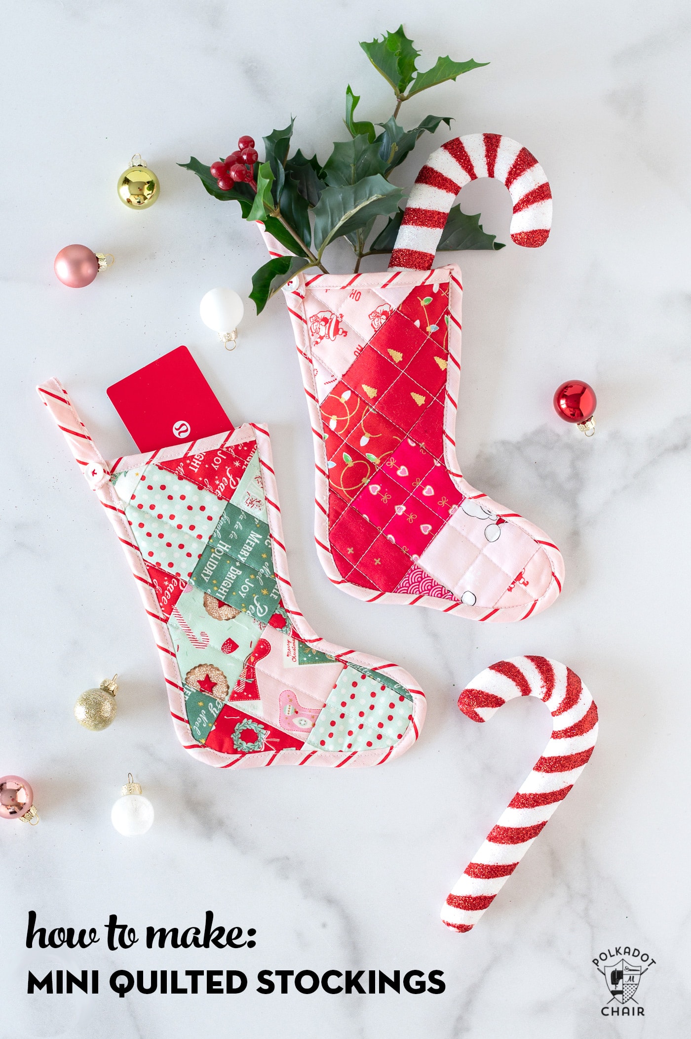 Pink and red mini quilted stockings on white tabletop with Christmas decorations