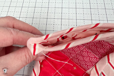 pink and red Christmas stocking in construction process on white cutting mat