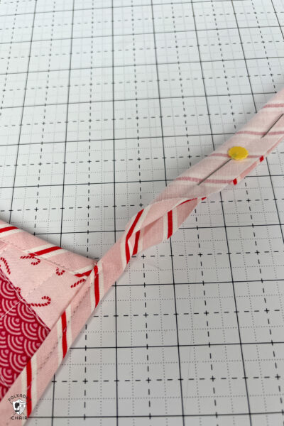 pink and red Christmas stocking in construction process on white cutting mat