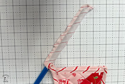 pink and red Christmas stocking in construction process on white cutting mat