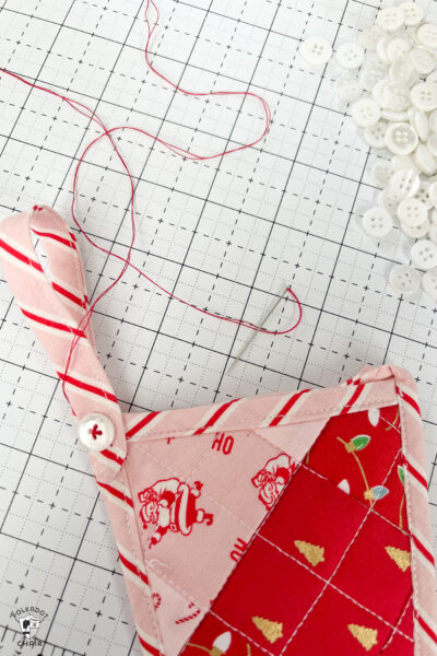 pink and red Christmas stocking in construction process on white cutting mat