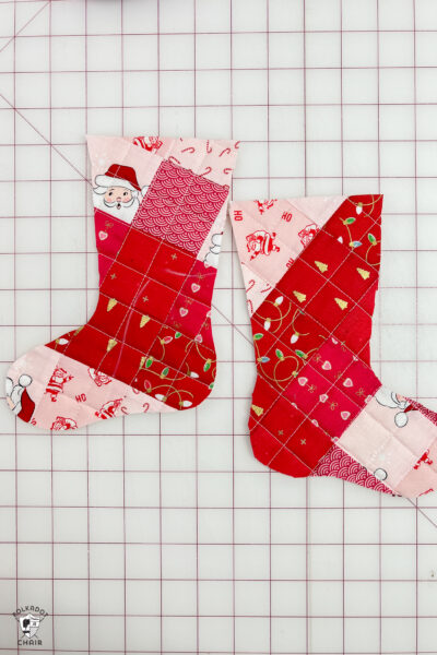 pink and red Christmas stocking in construction process on white cutting mat