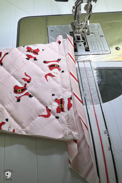 pink and red Christmas stocking in construction process on white cutting mat