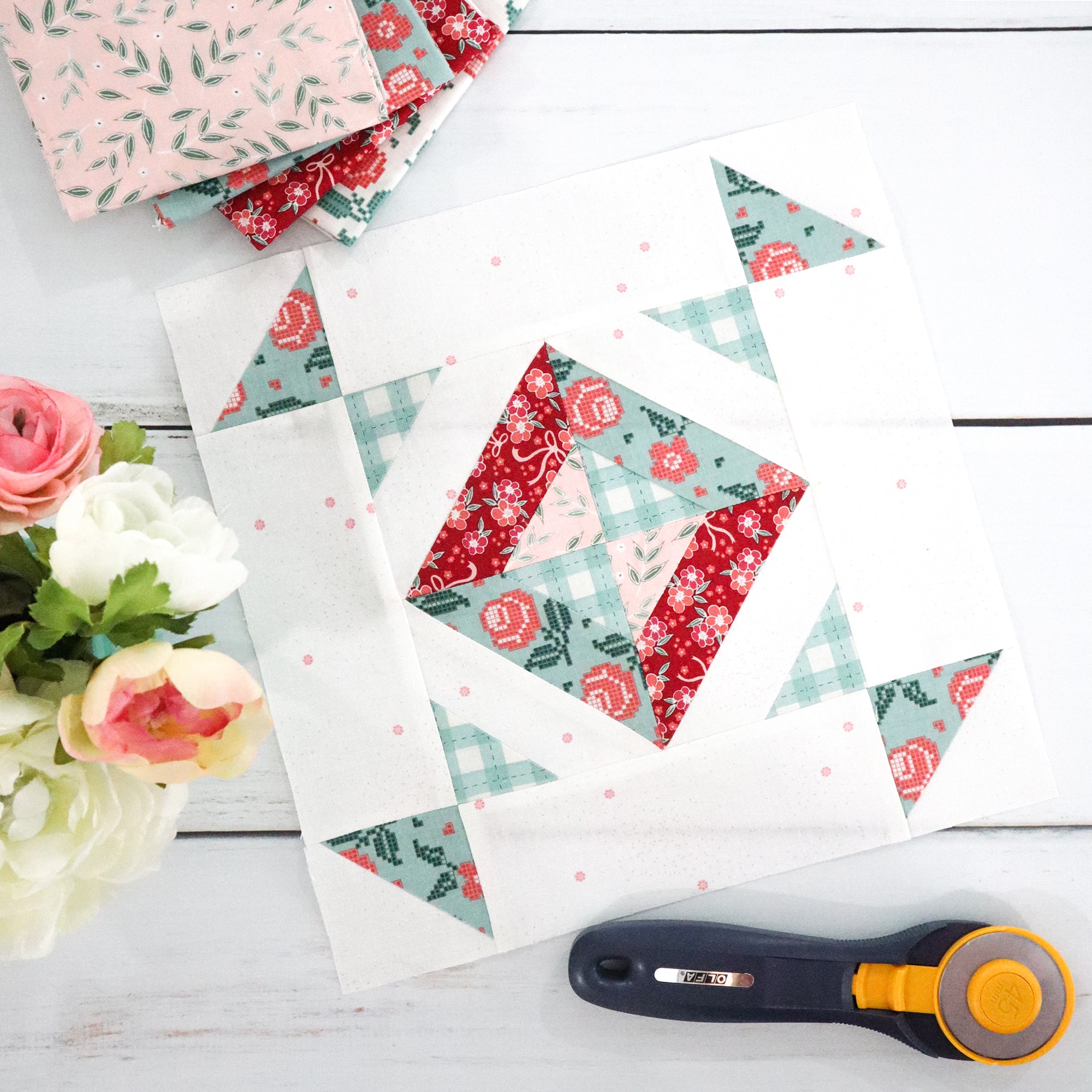 red and blue quilt block on table with flowers