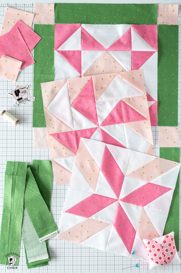 Pink and white quilt blocks on cutting mat with green fabric
