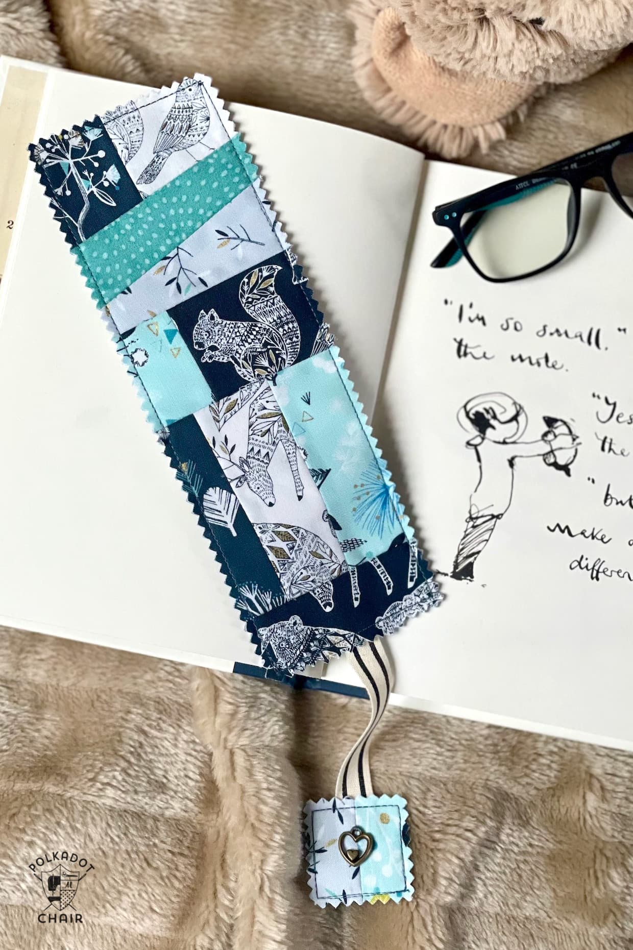 Blue patchwork bookmark on book on tan blanket