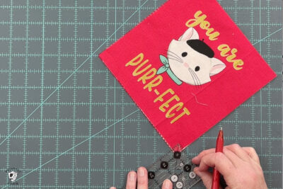 red fabric on cutting mat with ruler and scissors