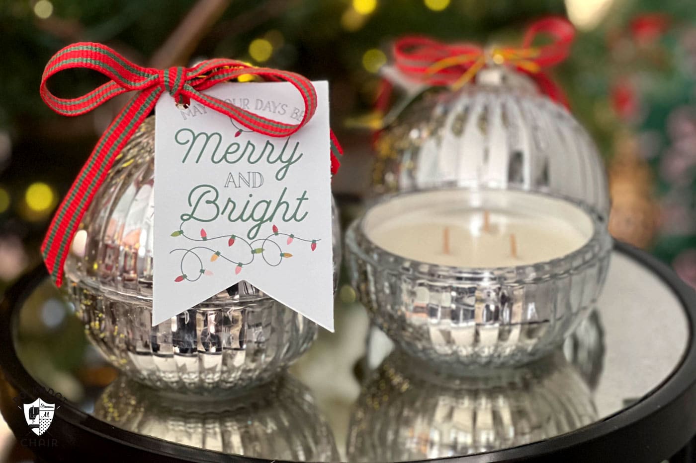 gift tag tied to round candle in front of Christmas tree