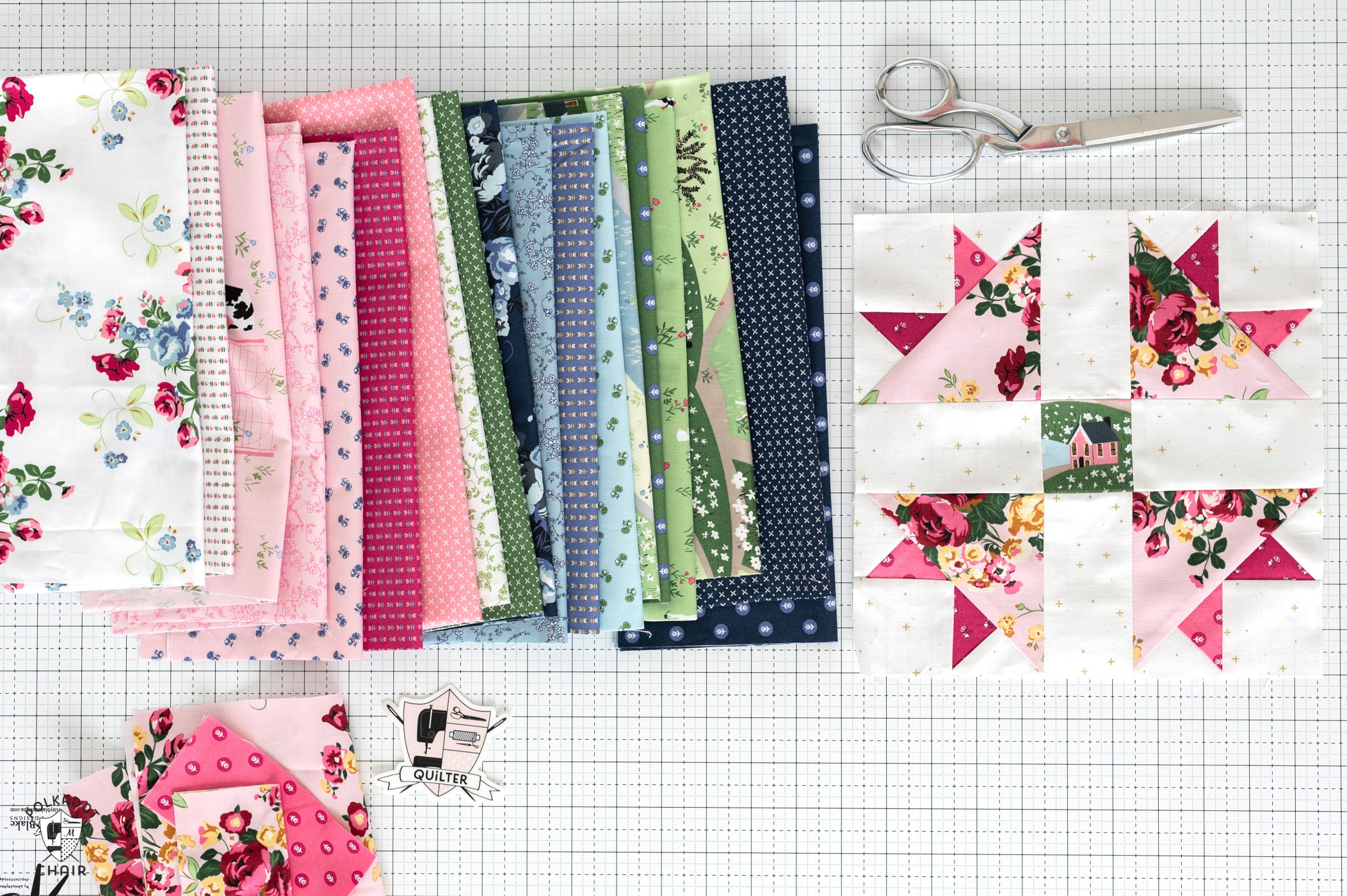 pink quilt block on cutting table with stack of fabric