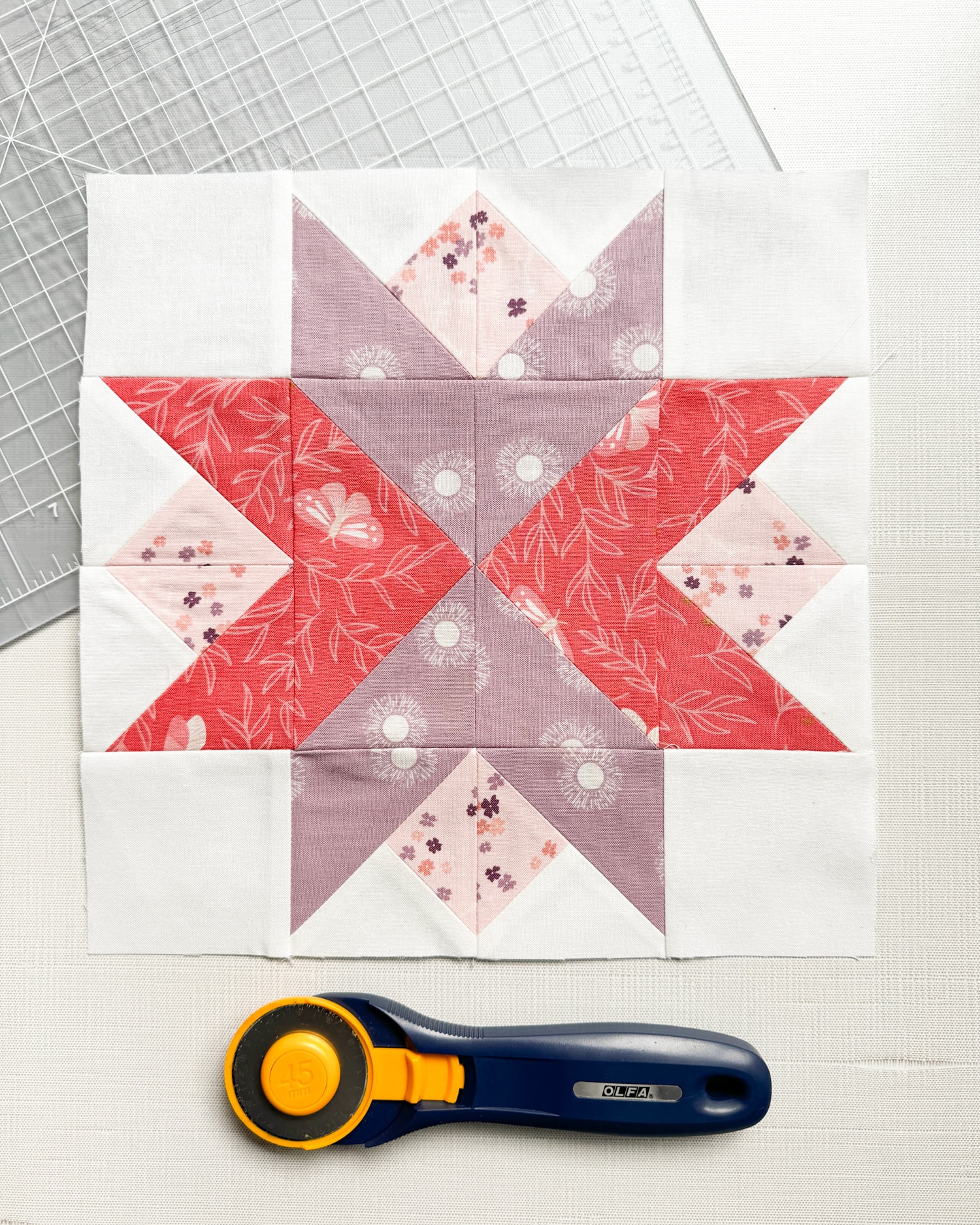 pink, coral and lavender quilt block on white table