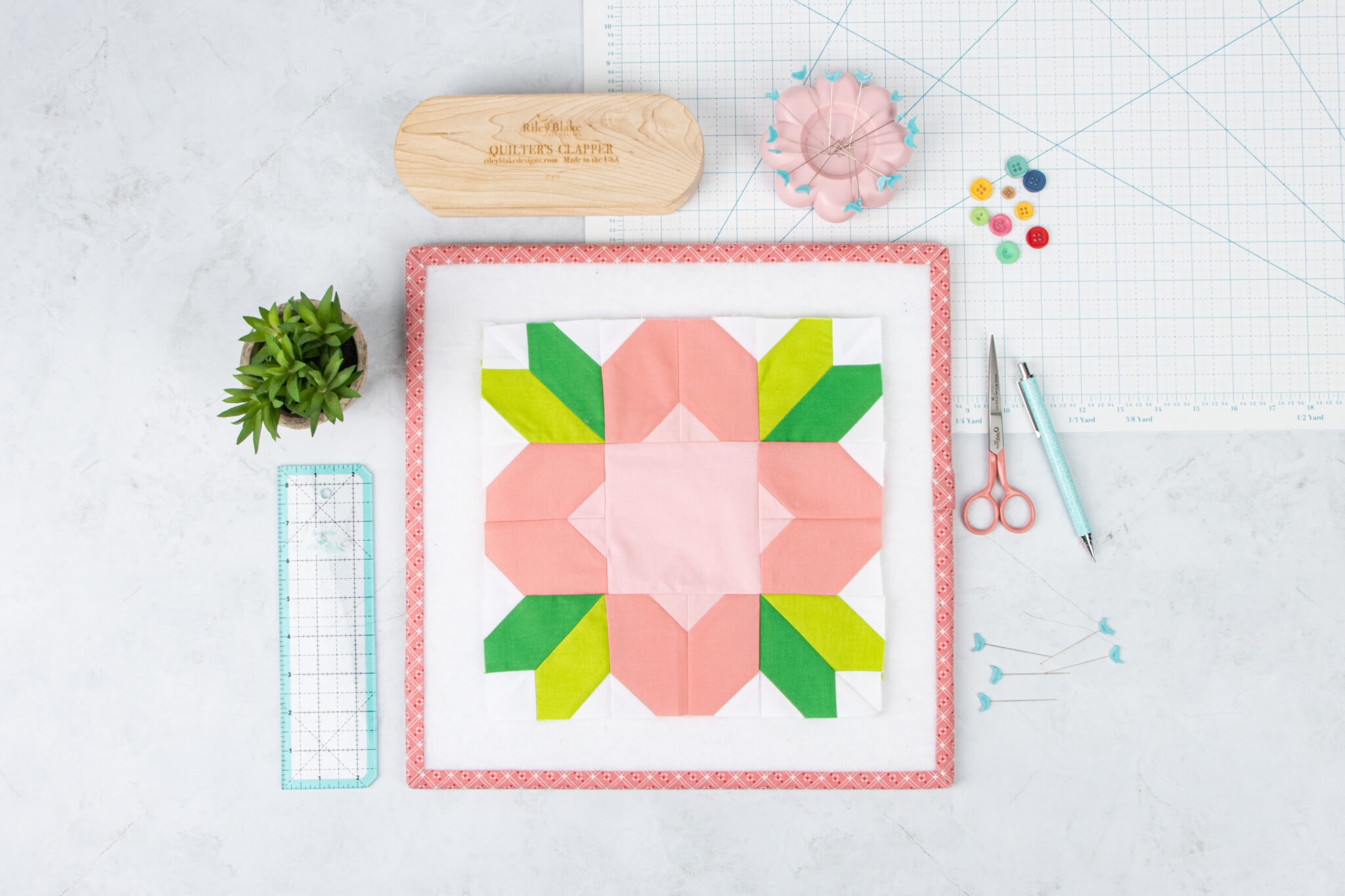 light pink and green flower block on white table