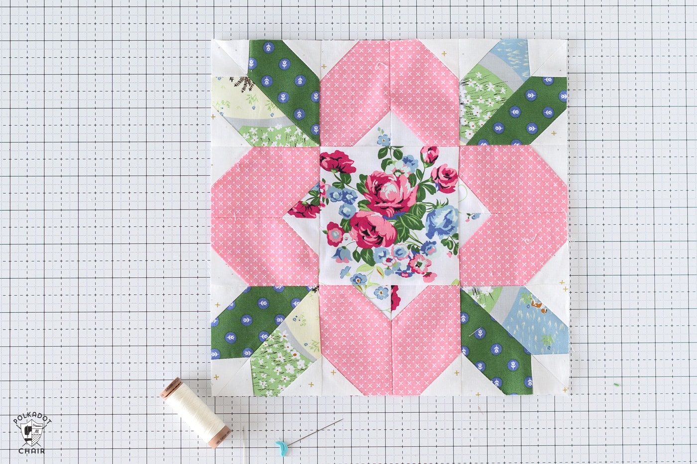 pink and green floral quilt block on white cutting mat