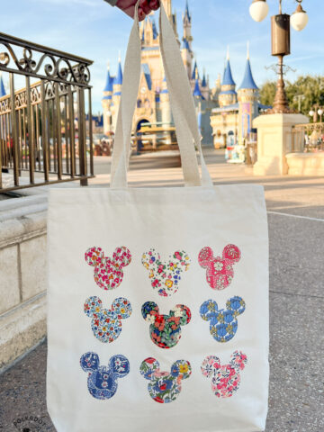 Tote bag with many Mickey mouse shapes in front of castle at disney world