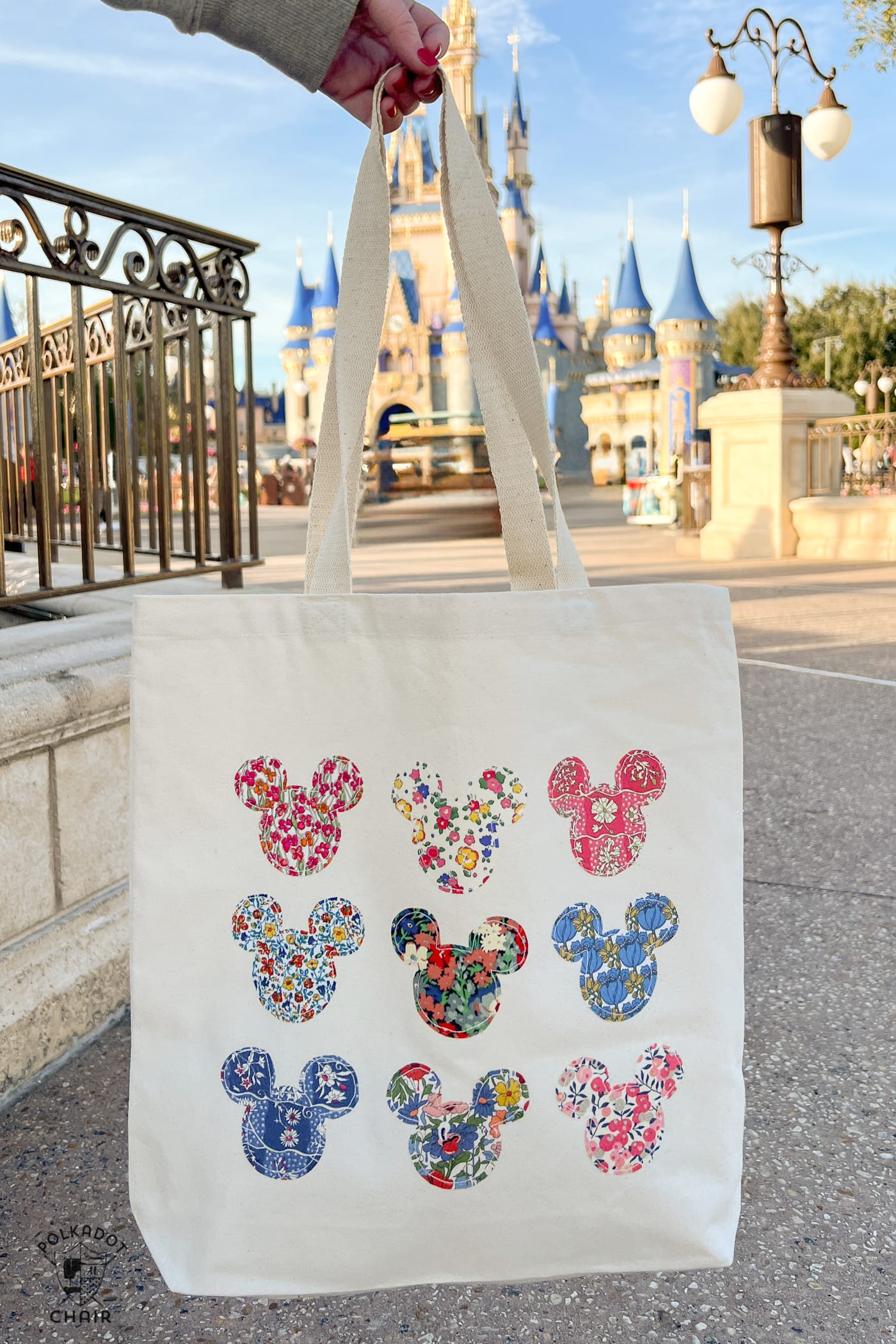 Tote bag with many Mickey mouse shapes in front of castle at disney world