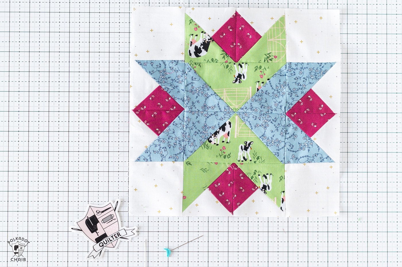 blue, red and green star quilt block on white cutting mat