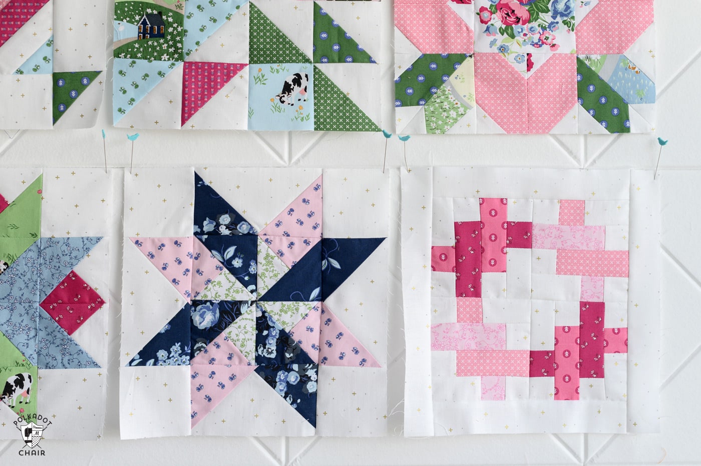 multiple pink and green and blue quilt blocks on white wall