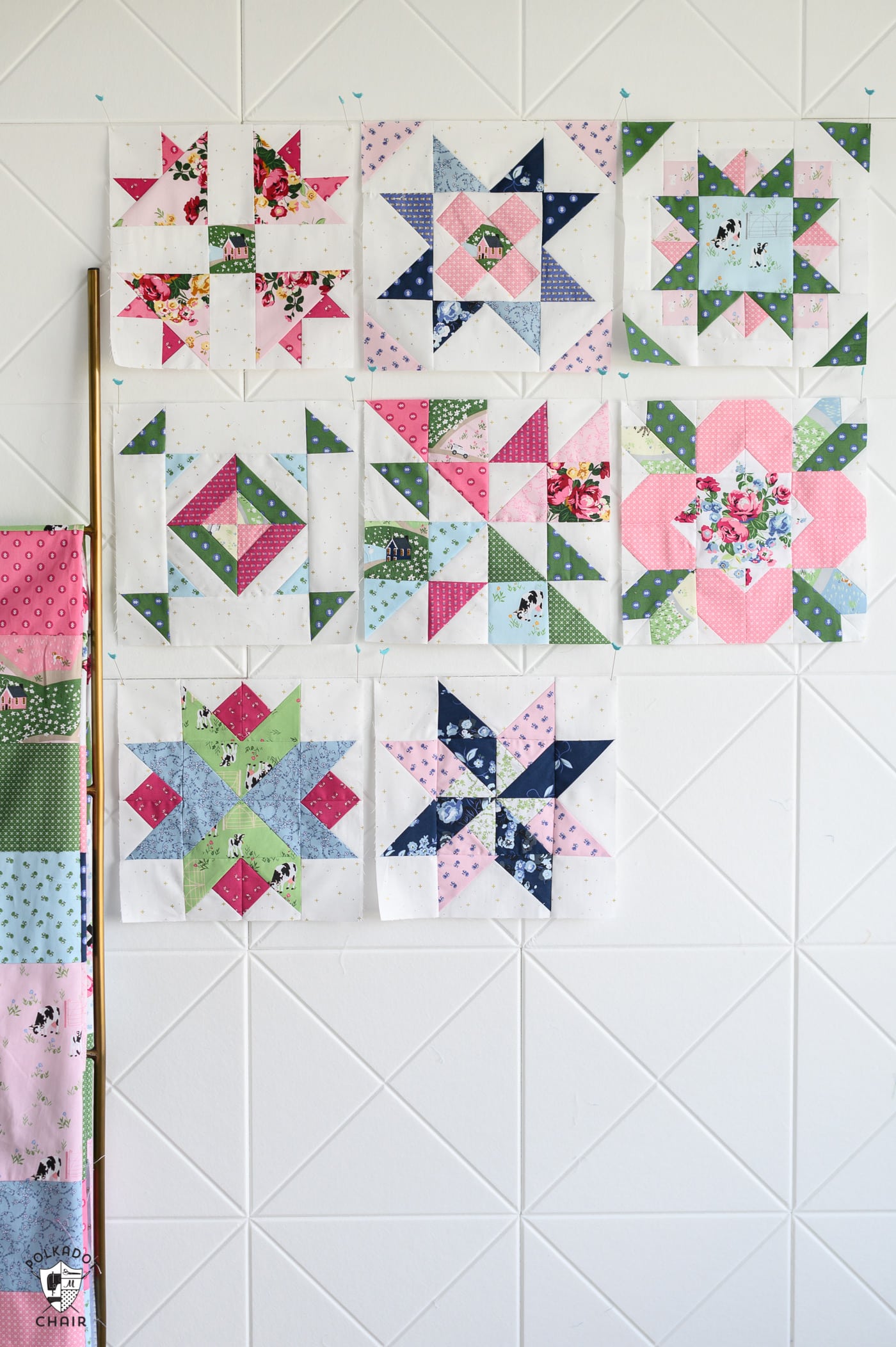 multiple pink and green and blue quilt blocks on white wall