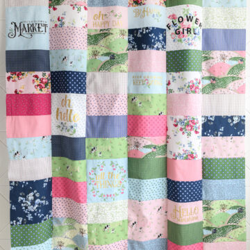 Pink, green and blue quilt made using rectangles of fabric.