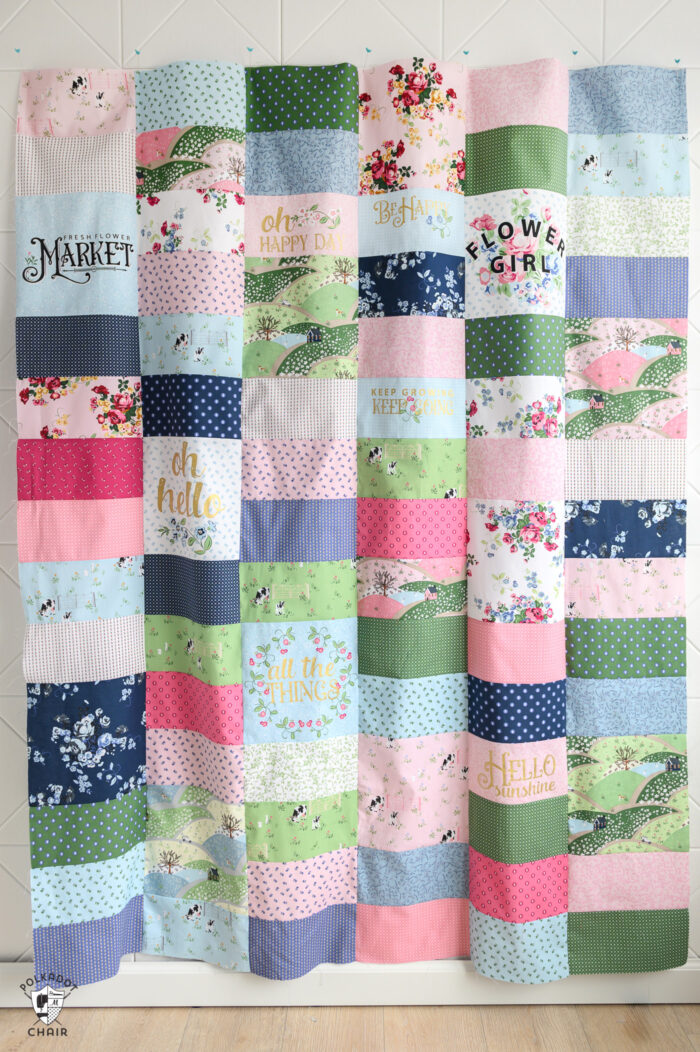 Pink, green and blue quilt made using rectangles of fabric.