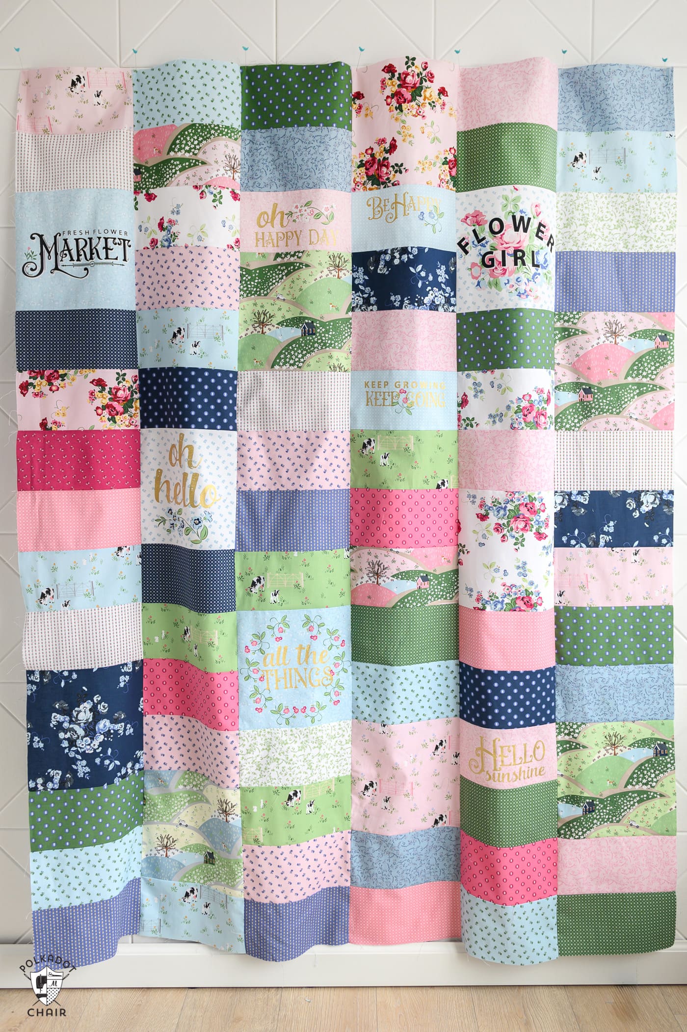 Pink, green and blue quilt made using rectangles of fabric.
