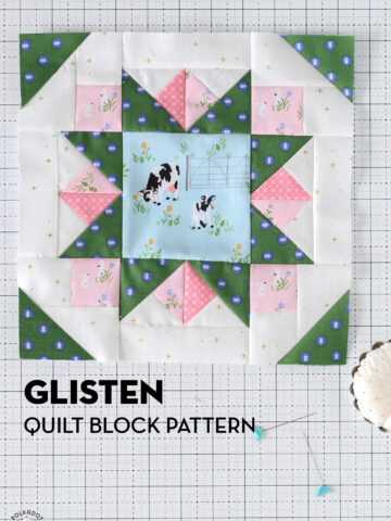 green star quilt block with pink accents on white cutting mat