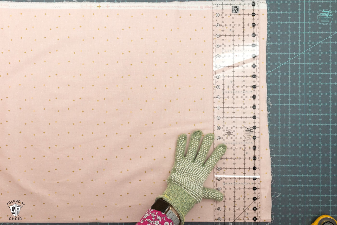 pink fabric being cut on blue cutting mat