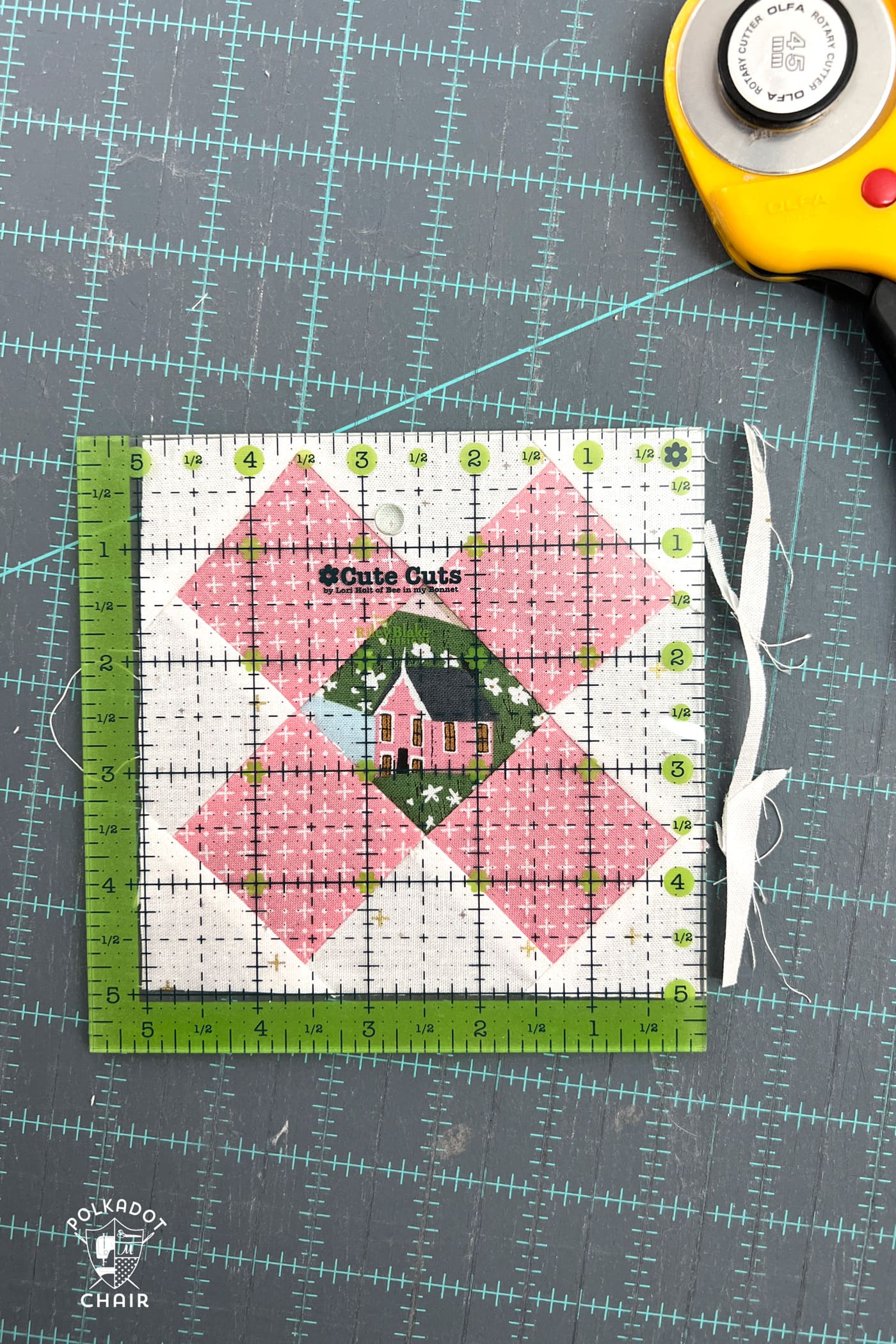 pink and white quilt block on blue cutting mat