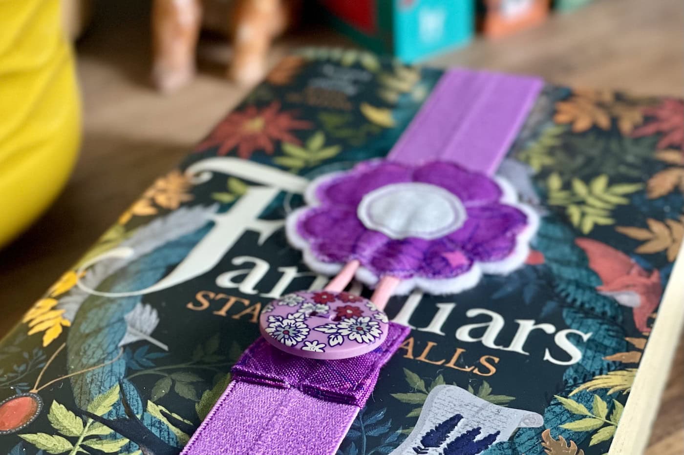purple elastic bookmark attached to book on wood table