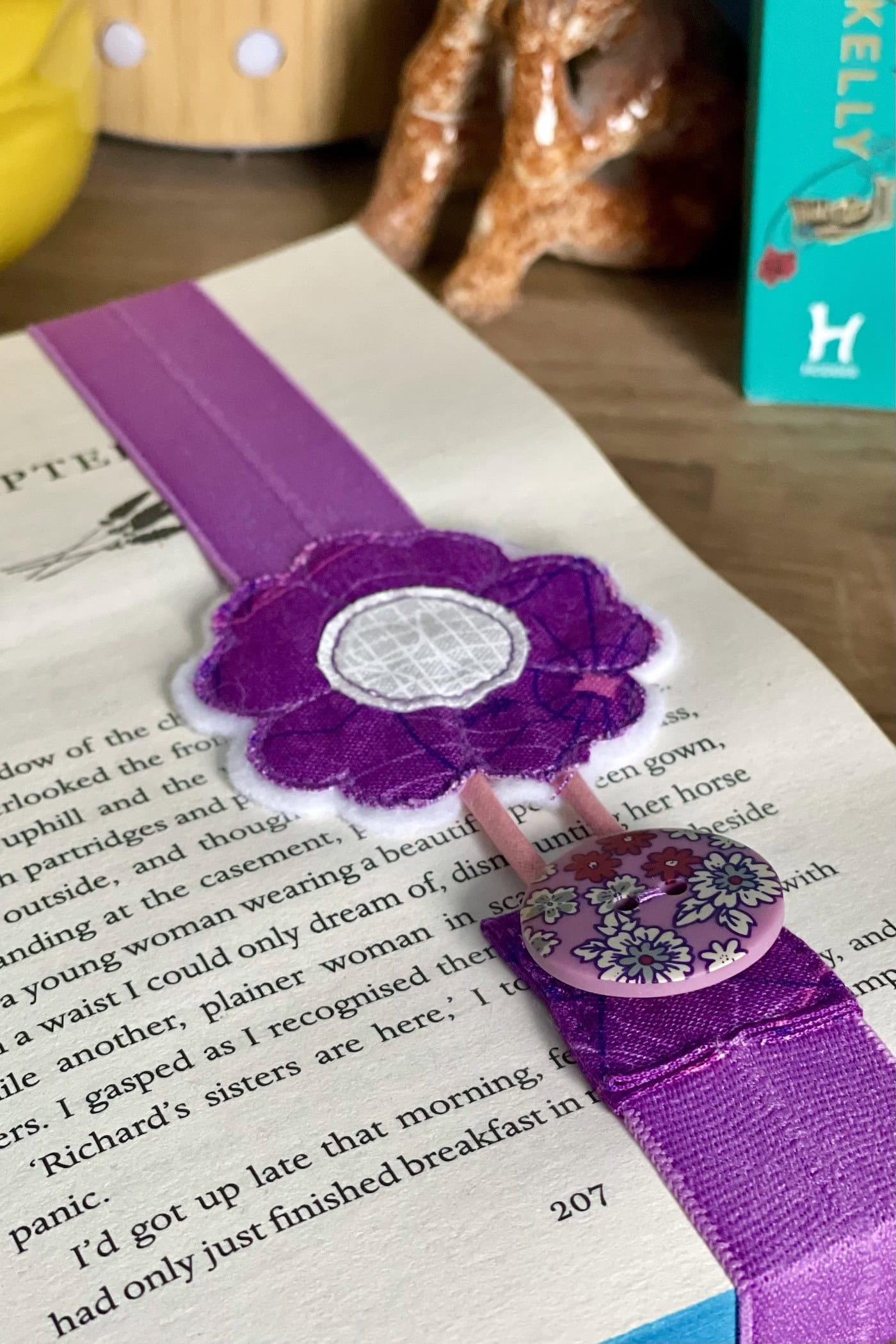 purple elastic bookmark attached to book on wood table