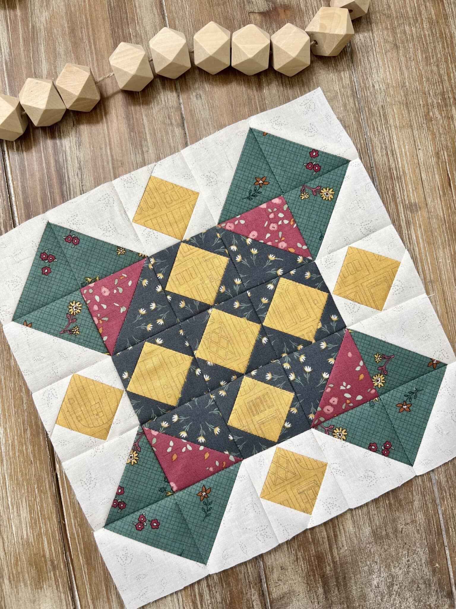 green, red and yellow quilt block on wood table