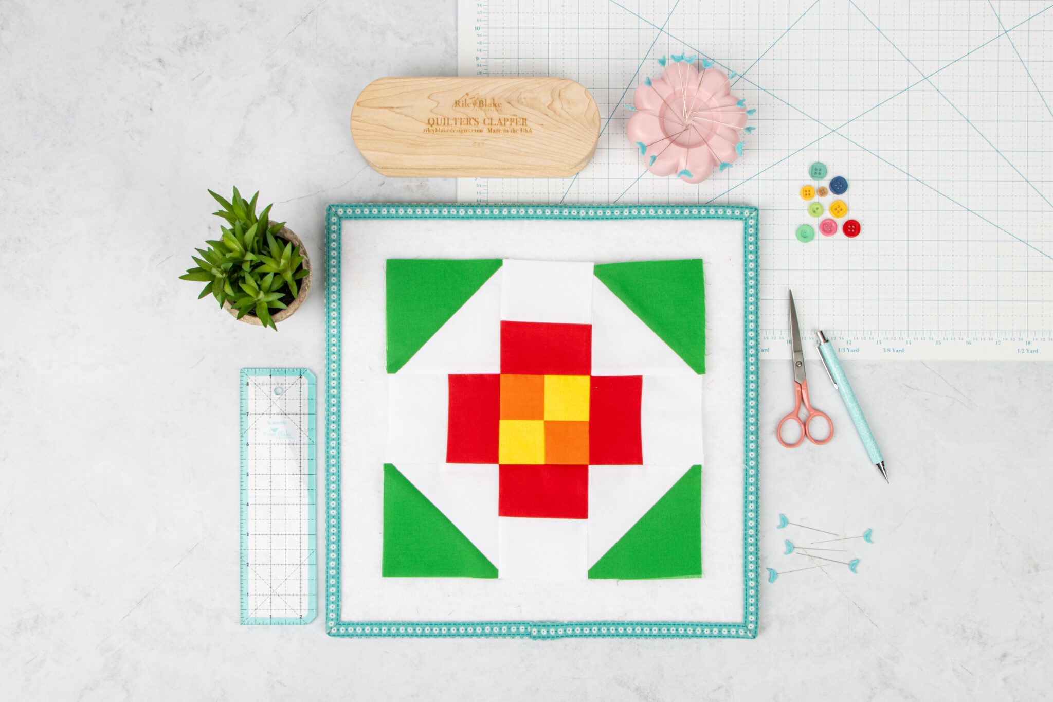 red, yellow and green quilt block with sewing notions