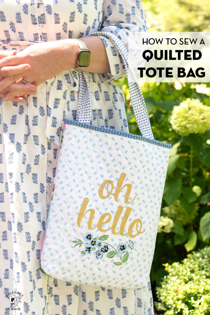 woman holding blue and white tote bag outdoors