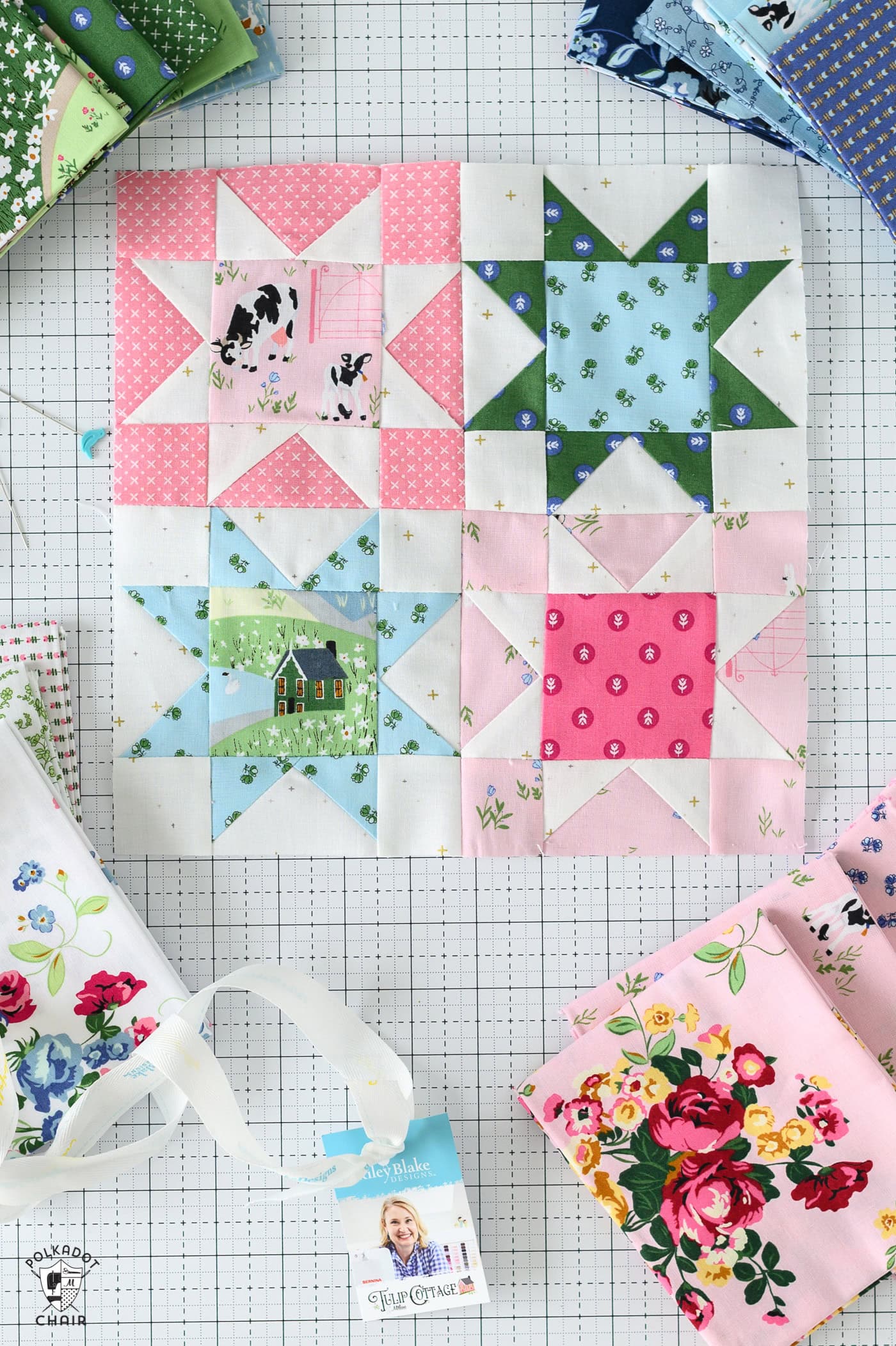 a pink, blue and green sawtooth star quilt block on white cutting mat with sewing notions and fabric scraps