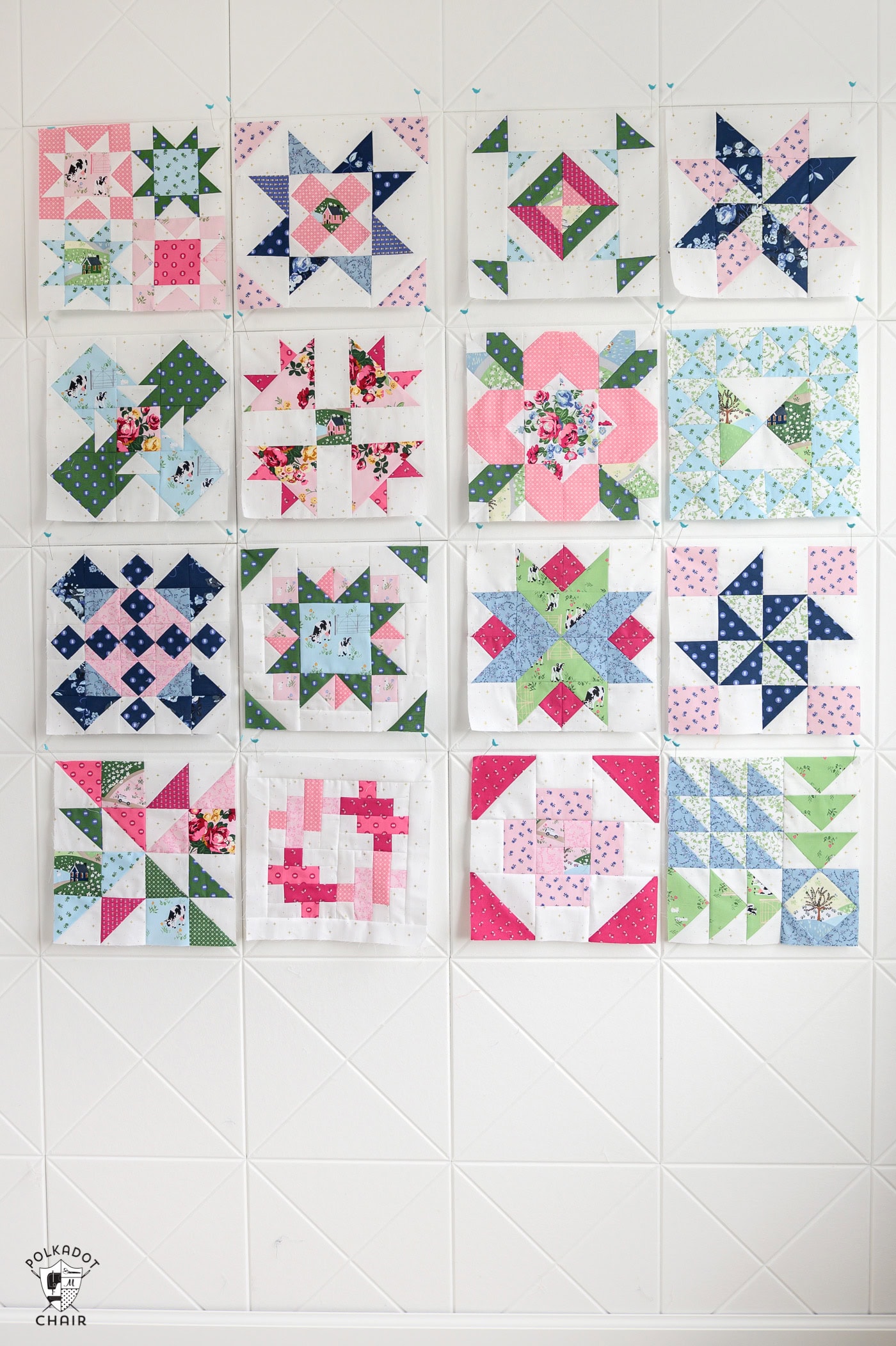 many colorful quilt blocks pinned on a white wall