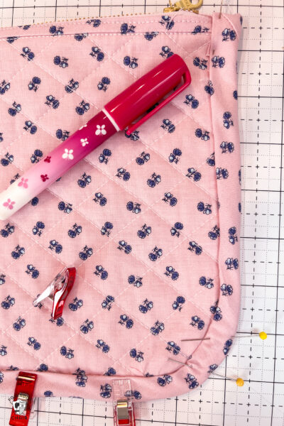 pink bag during construction process on white cutting mat with zipper and glue pen