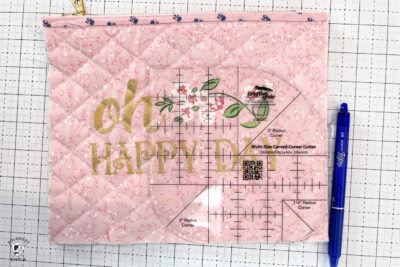 pink bag during construction process on white cutting mat with zipper and ruler