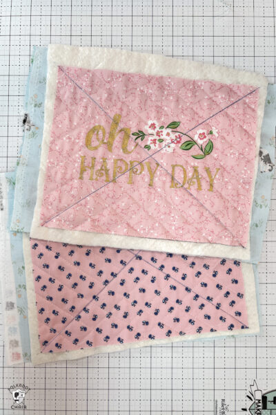 two pieces of quilted fabric on white cutting mat
