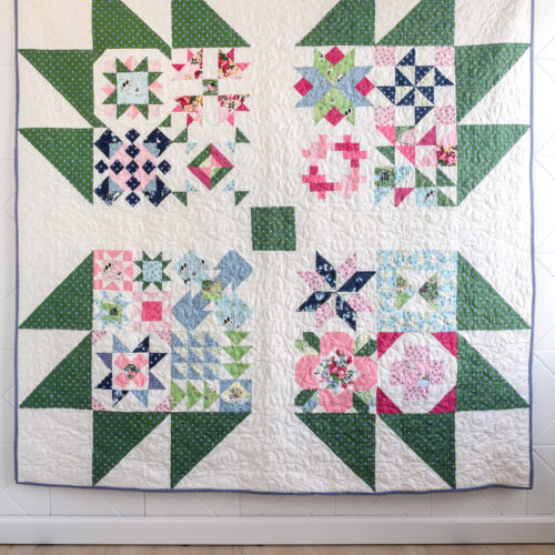blue, green, pink and white quilt on white wall
