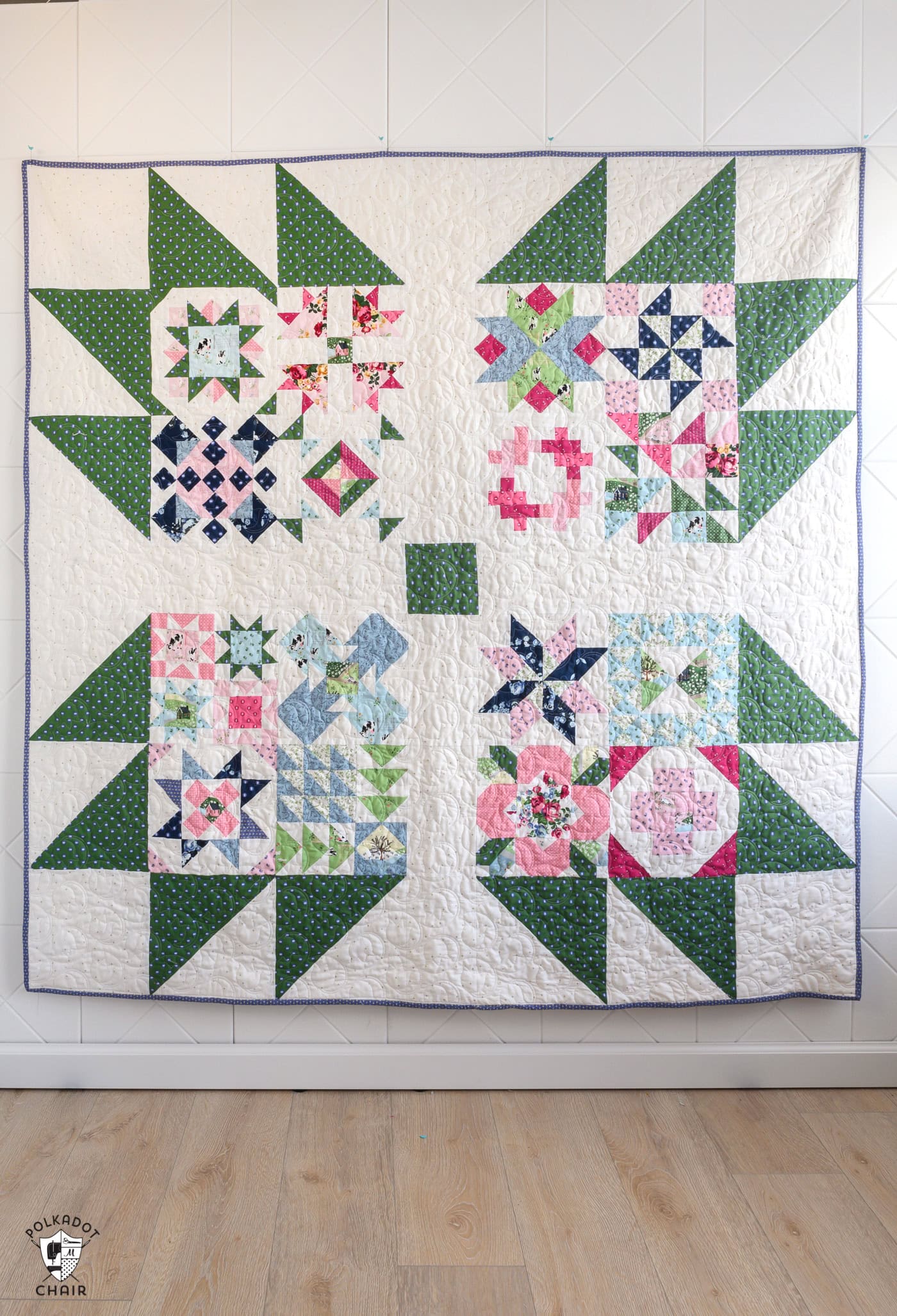 blue, green, pink and white quilt on white wall