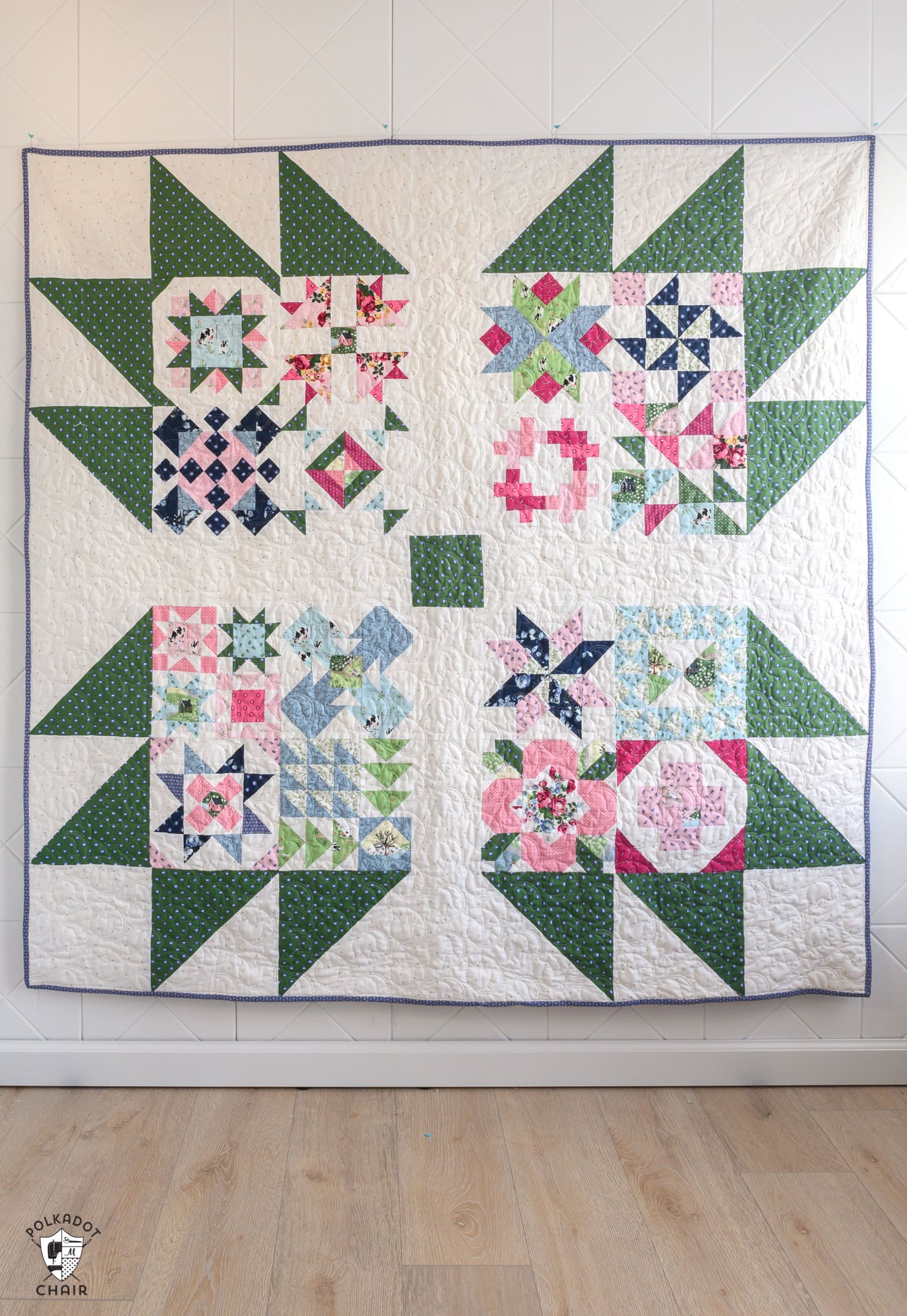 blue, green, pink and white quilt on white wall