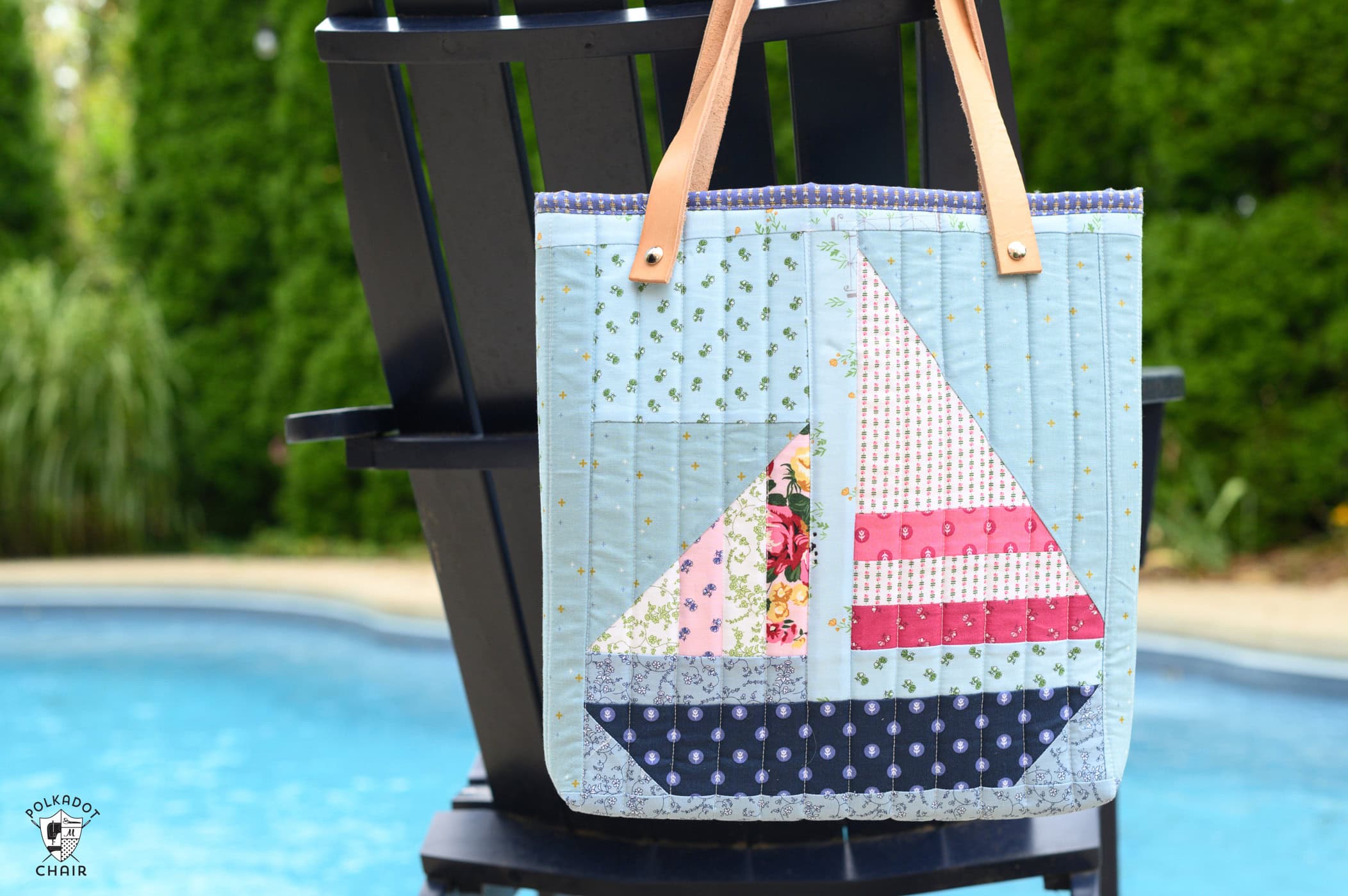 quilted tote bag on navy chair next to pool