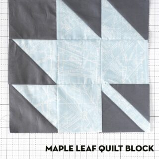 gray and blue maple leaf quilt block on white cutting mat