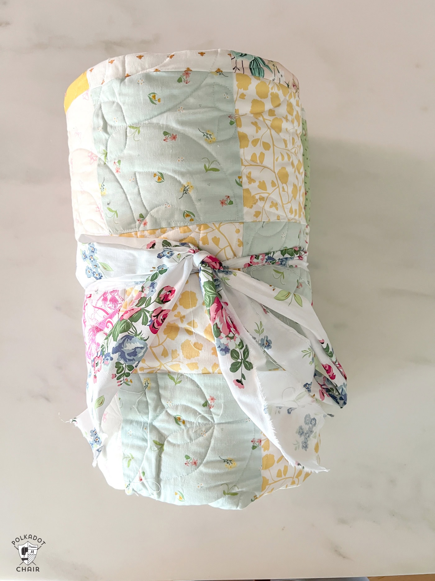 patchwork quilt rolled up on marble countertop